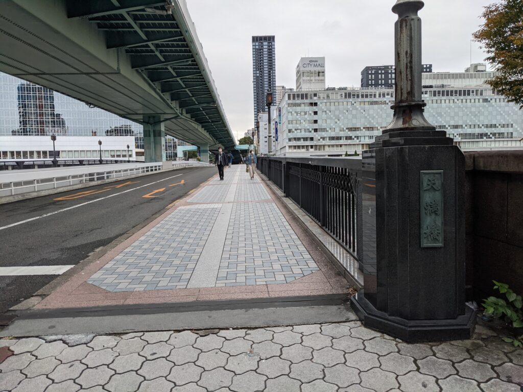 大阪の天満橋、歩行者が行き交う現役の橋と背景の京阪シティモール
