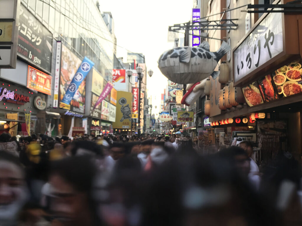 看板がひしめく道頓堀の通りとふぐの巨大看板