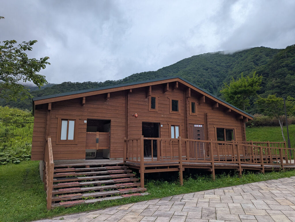 北海道浦河町の翠明橋公園内に建つ木造の休憩施設。山々に囲まれた自然の中で旅人が休める温かみのある建物。