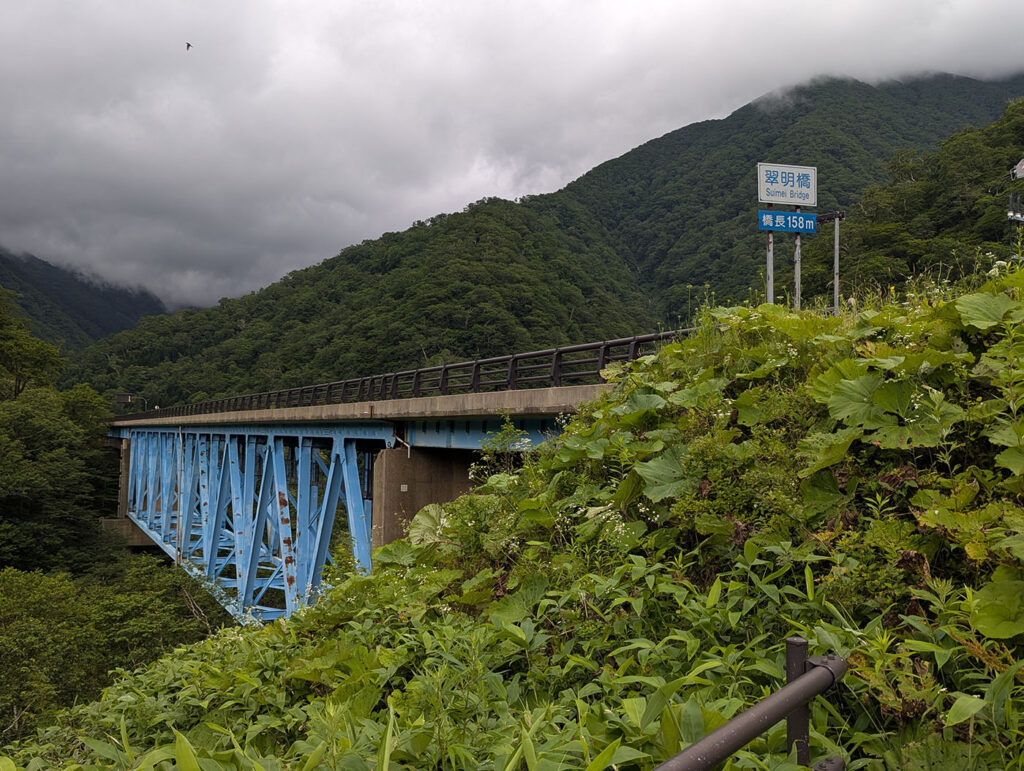 北海道・浦河の翠明橋。青い橋脚が山の緑に映える姿。