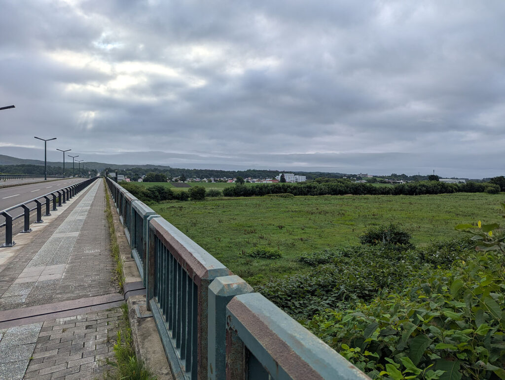 池田大橋から望む牧草地と町並み、曇り空の風景