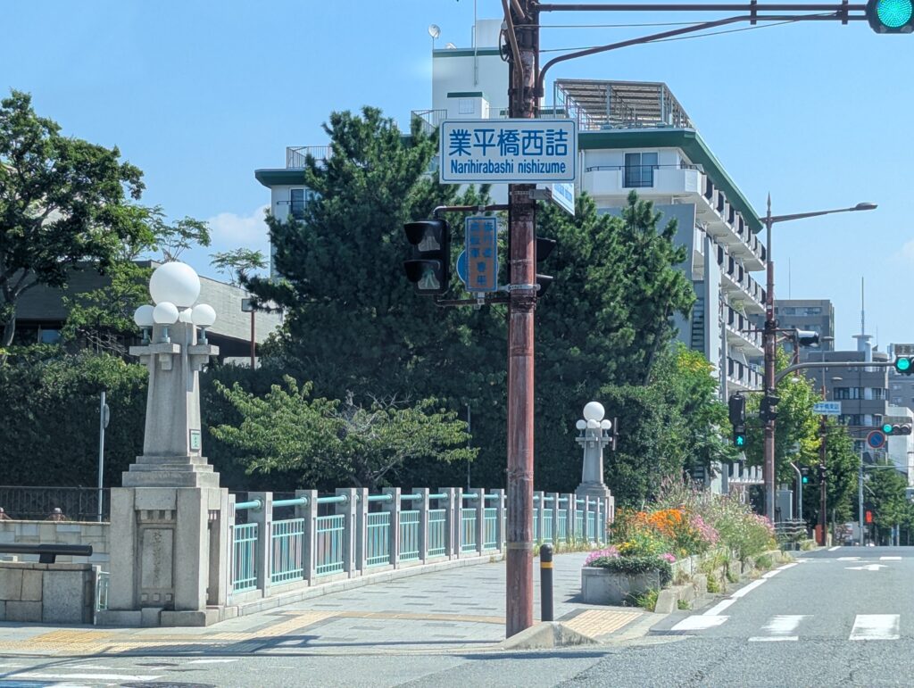 業平橋西詰から見た橋全体と緑色の欄干、花壇が整備された歩道